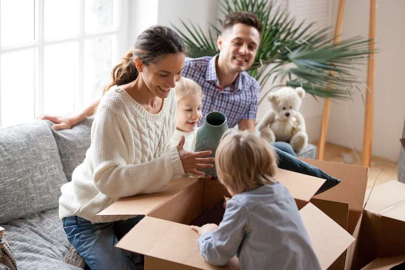 Nuevo modelos financieros para mejorar el acceso a la vivienda en México - happy family with kids unpacking boxes moving into new home